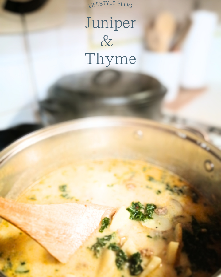 zuppa Toscana soup in silver pot with black cast iron Dutch over behind it